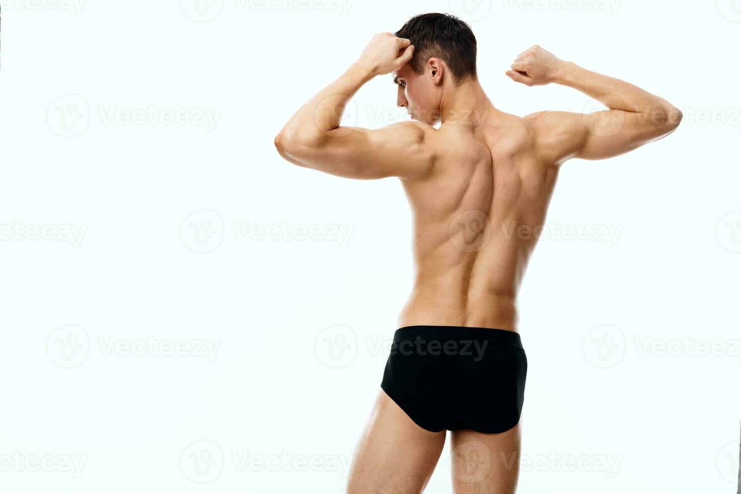hombre atleta en pantalones cortos participación manos detrás cabeza espalda ver aptitud carrocero foto