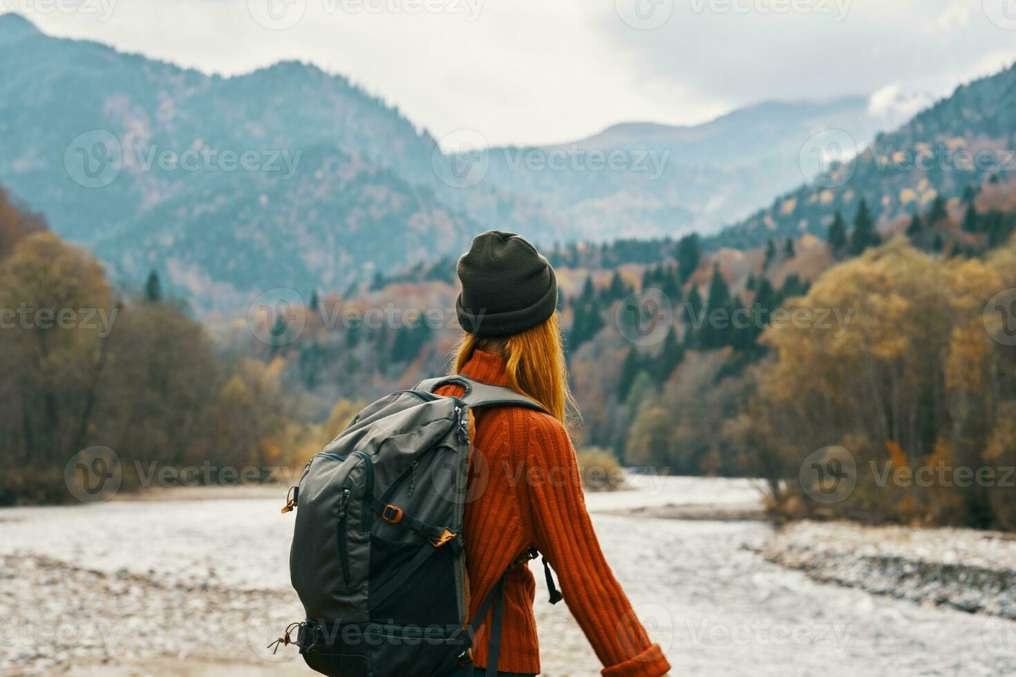 woman hiker with a backpack rest in the mountains in nature near the river photo