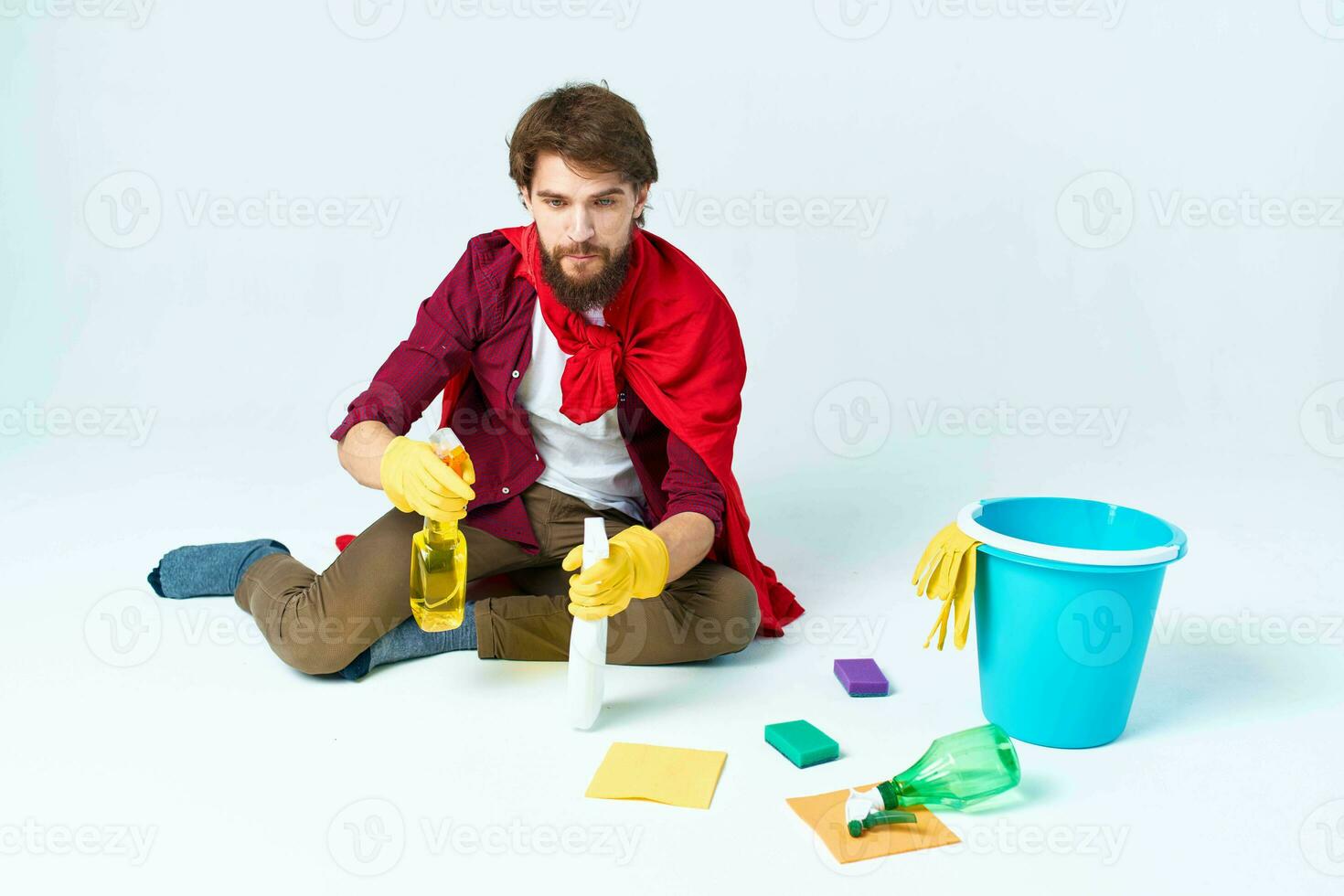 limpiador con limpieza suministros en un rojo impermeable en el piso de el casa interior foto