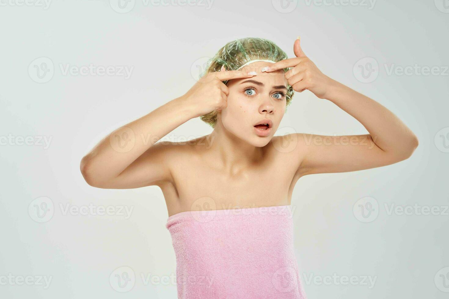 woman in a pink towel squeeze out black dots on her face skin problems photo