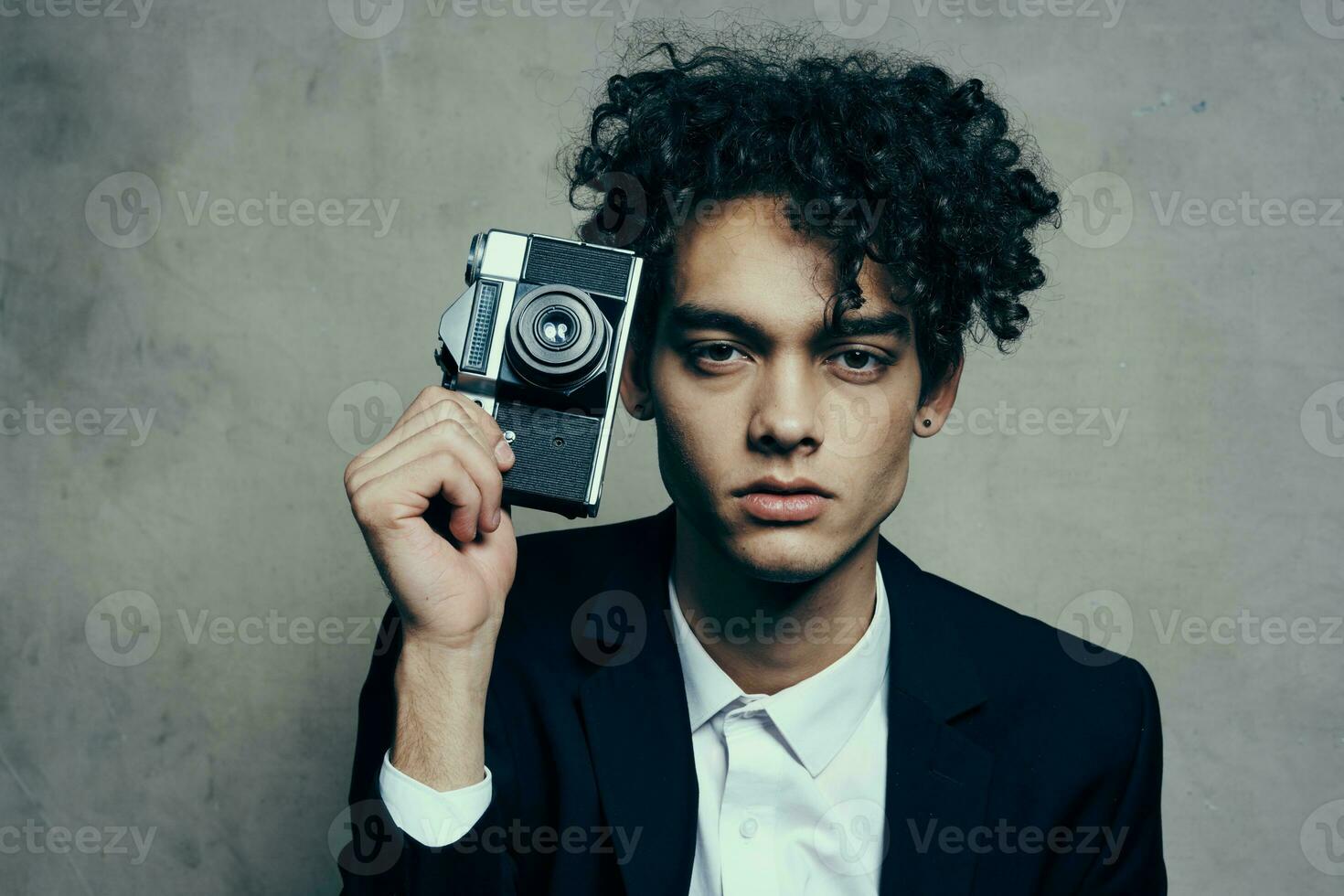 curly guy new technology camera studio gray background photo