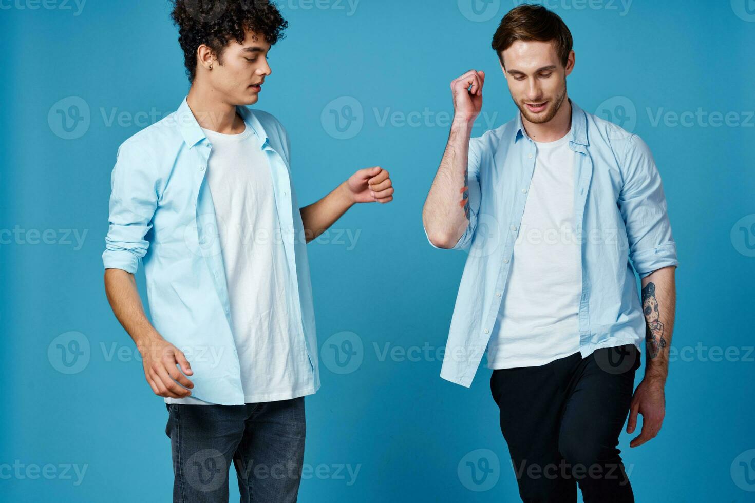two men on a blue background gesturing with their hands team friendship communication photo