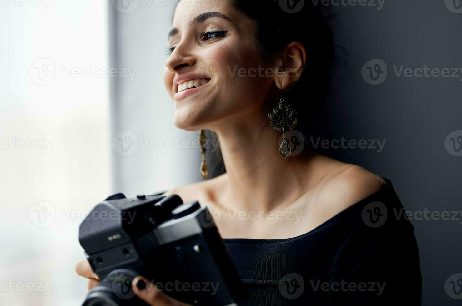 brunette in a black dress near the window posing lifestyle studio photo