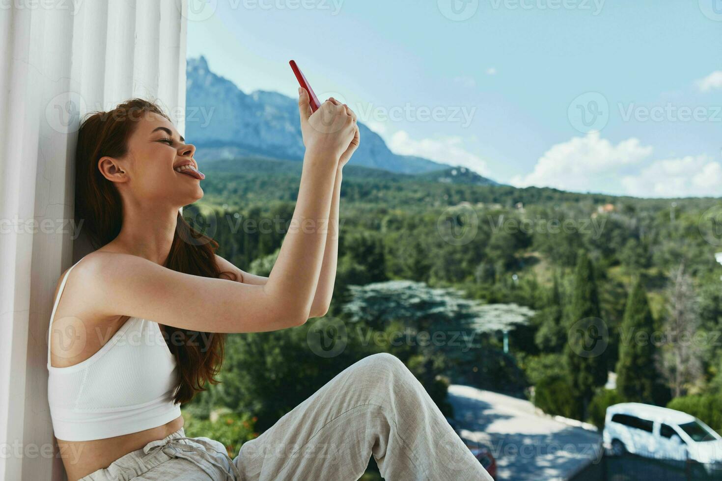 Portrait woman use the phone looks at the screen in a comfortable hotel an open view of the Lifestyle photo