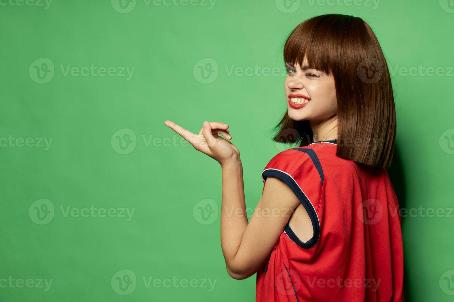 woman winks at the camera and points a finger to the side 23728029