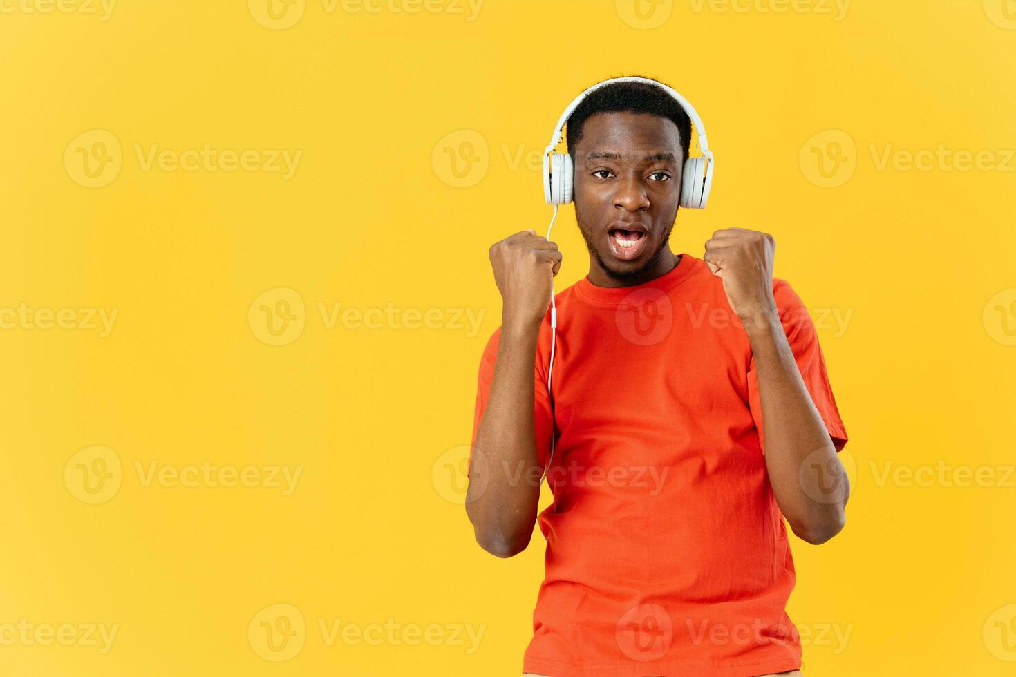 cheerful african man listening to music with headphones technology yellow background photo