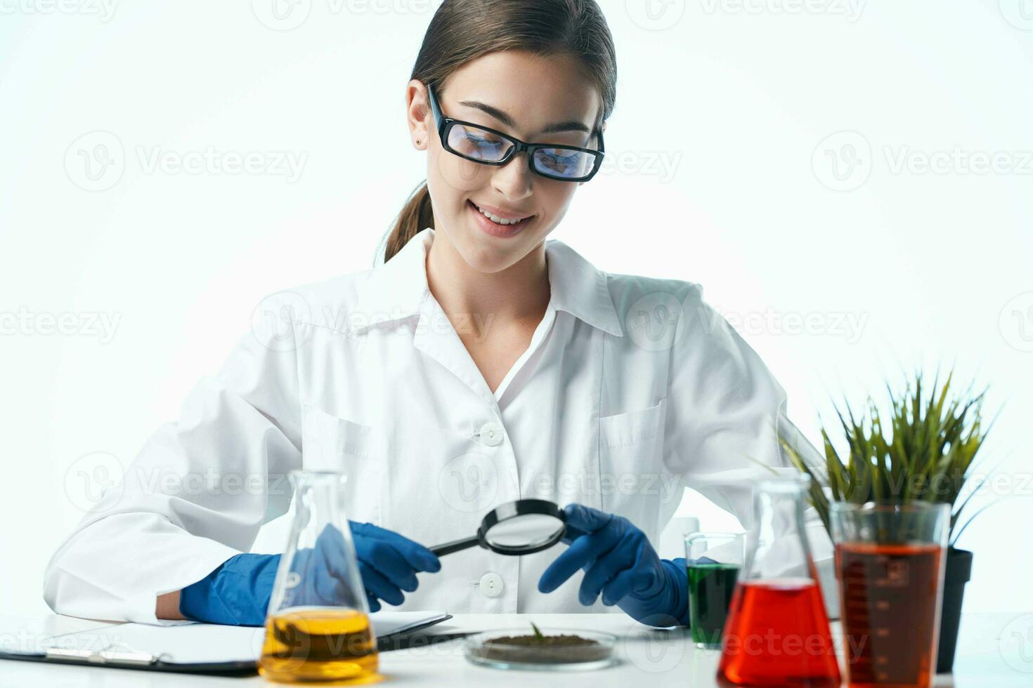 woman biologist white coat sitting at the table research plant photo