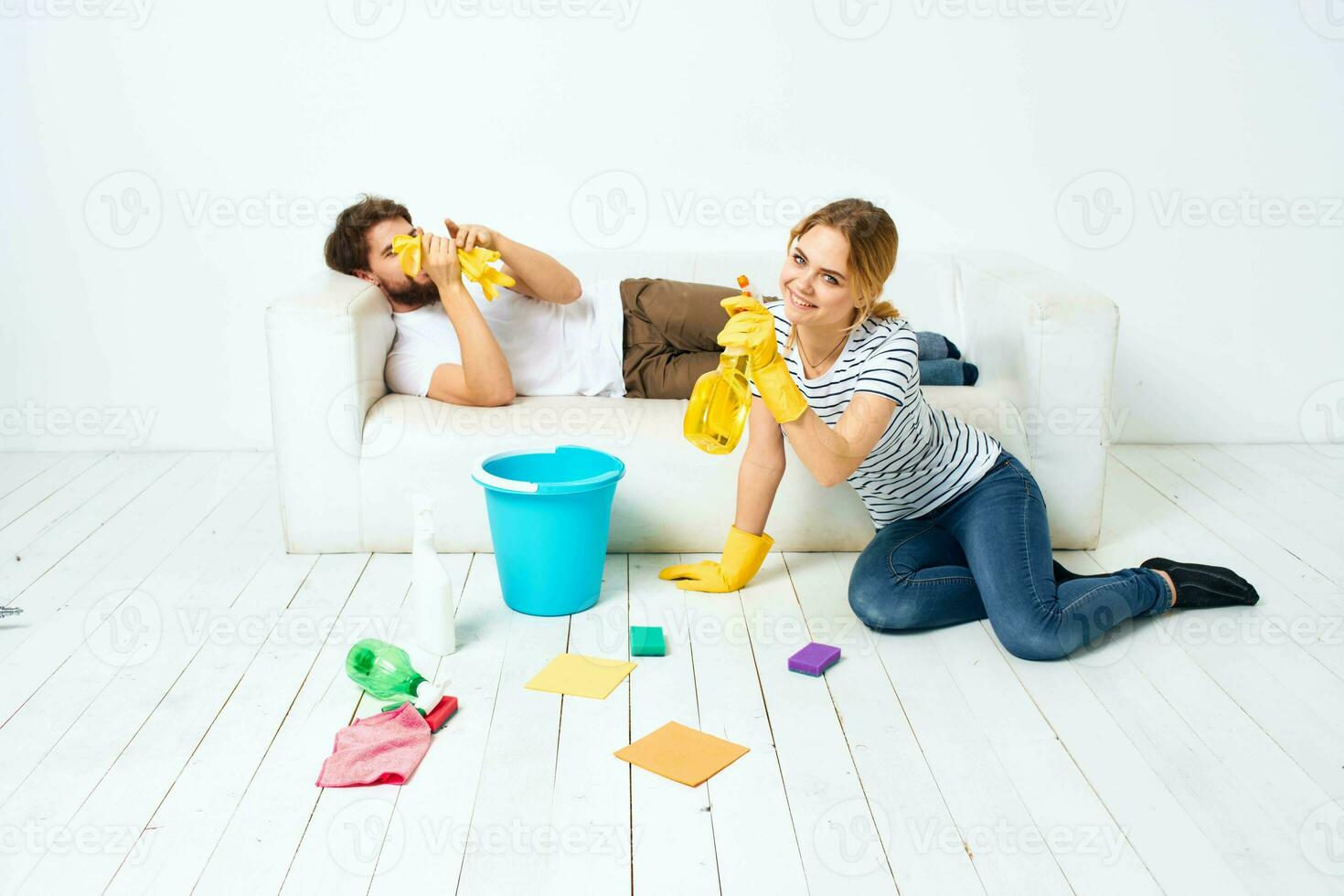 young couple at home near sofa washing supplies cleaning lifestyle photo