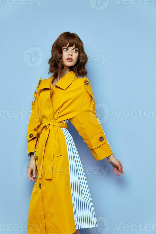 woman in yellow coat with buttons looks to the side photo