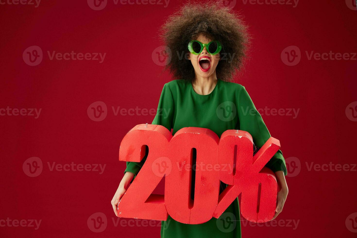 Portrait of a charming lady green dress afro hairstyle dark glasses twenty percent in hands studio model unaltered photo