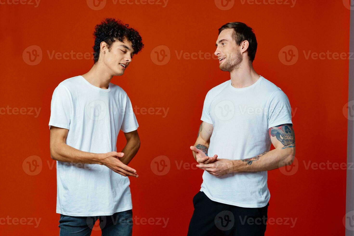 two friends in white t-shirts hugs communication red background photo