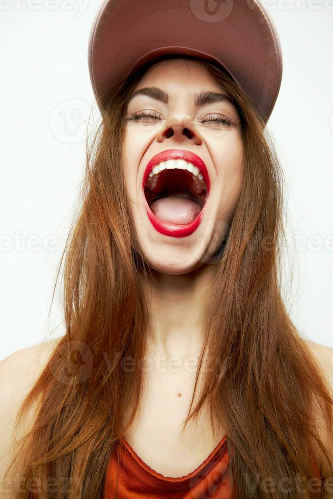Emotional woman in a cap Eyes closed, mouth wide open photo