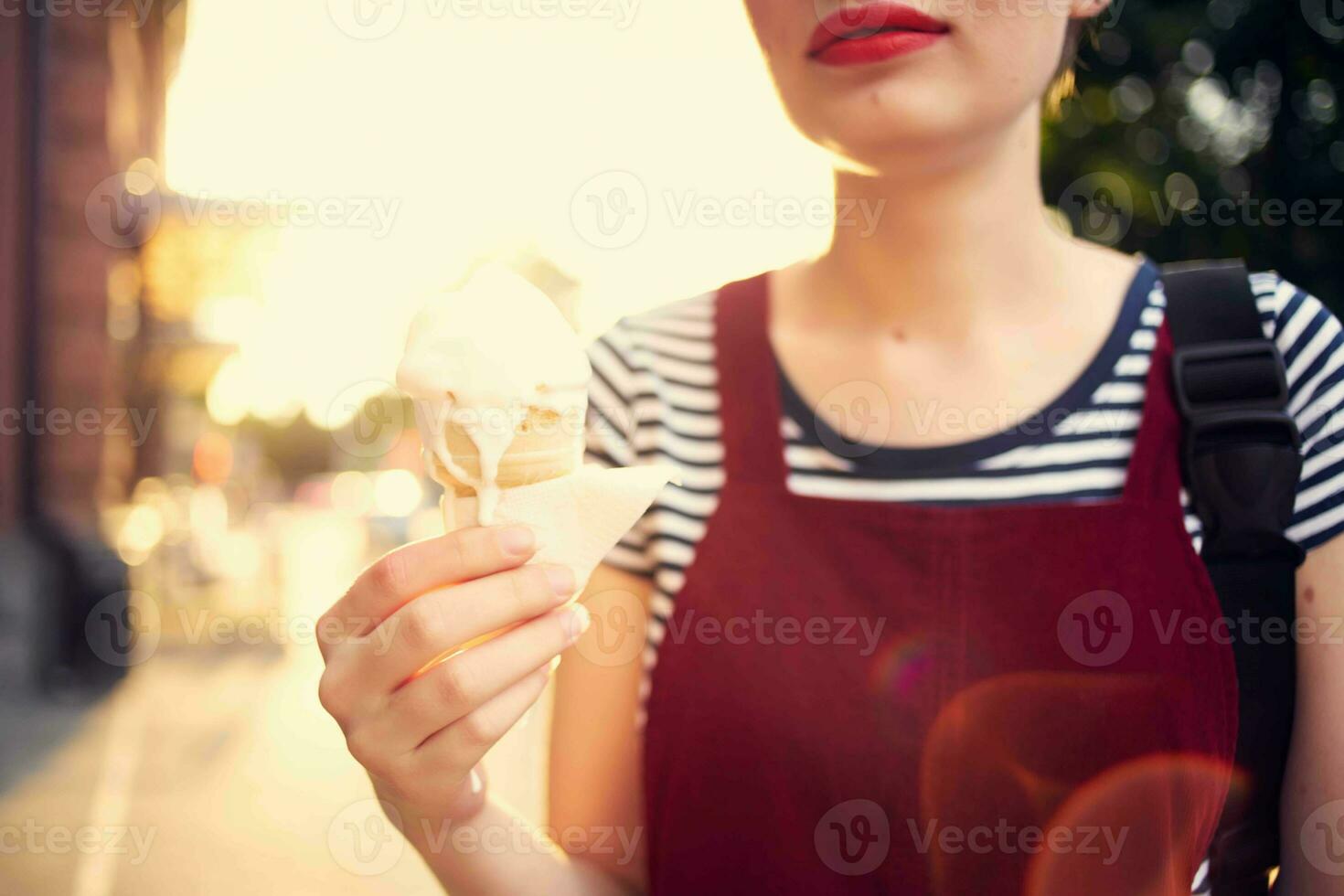 alegre mujer en el calle comiendo hielo crema caminar verano foto