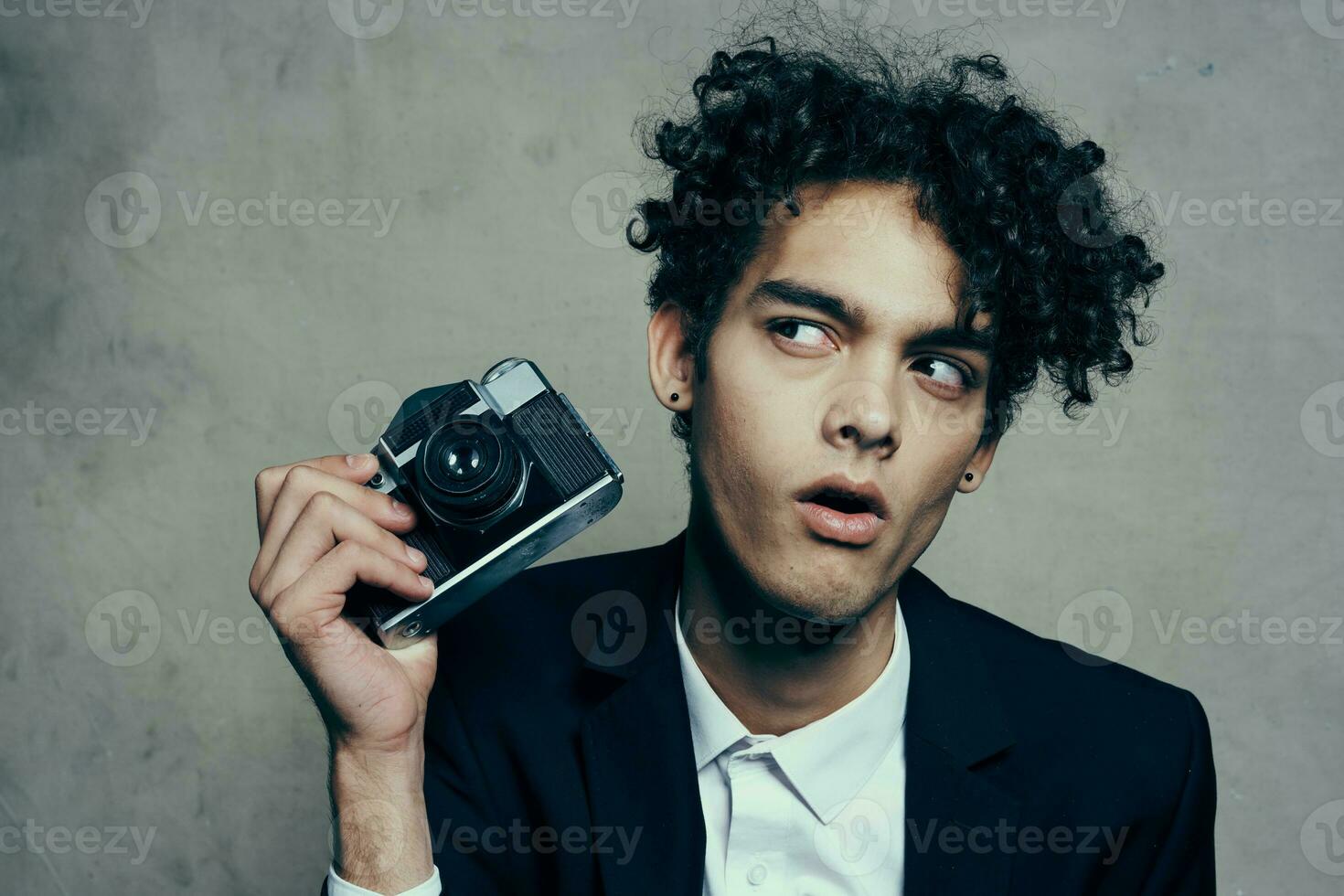 handsome guy in a suit with a camera lessons curly hair emotions model photo