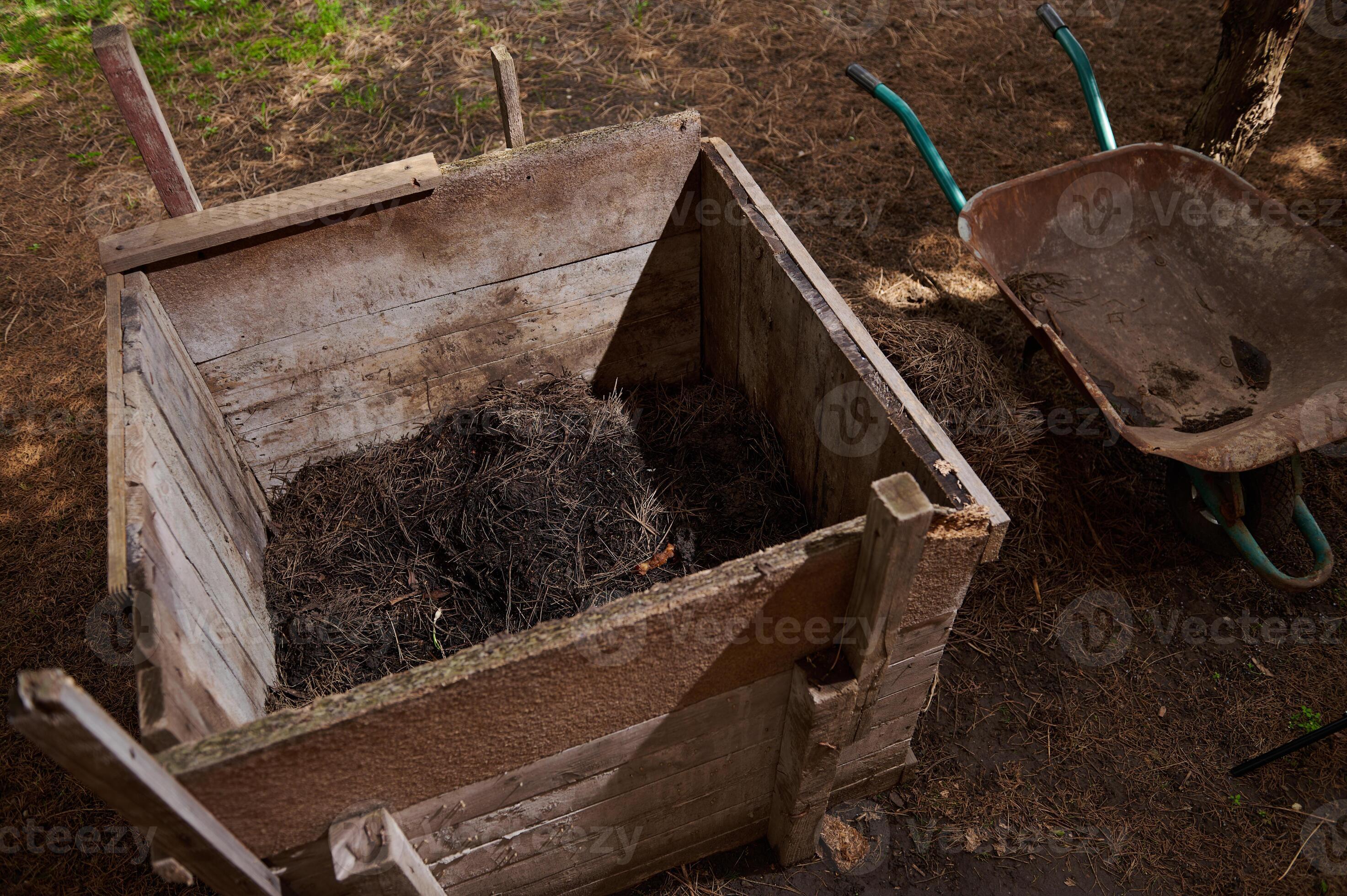 Compost heap. Compost pit on the plot of land. Wooden box for