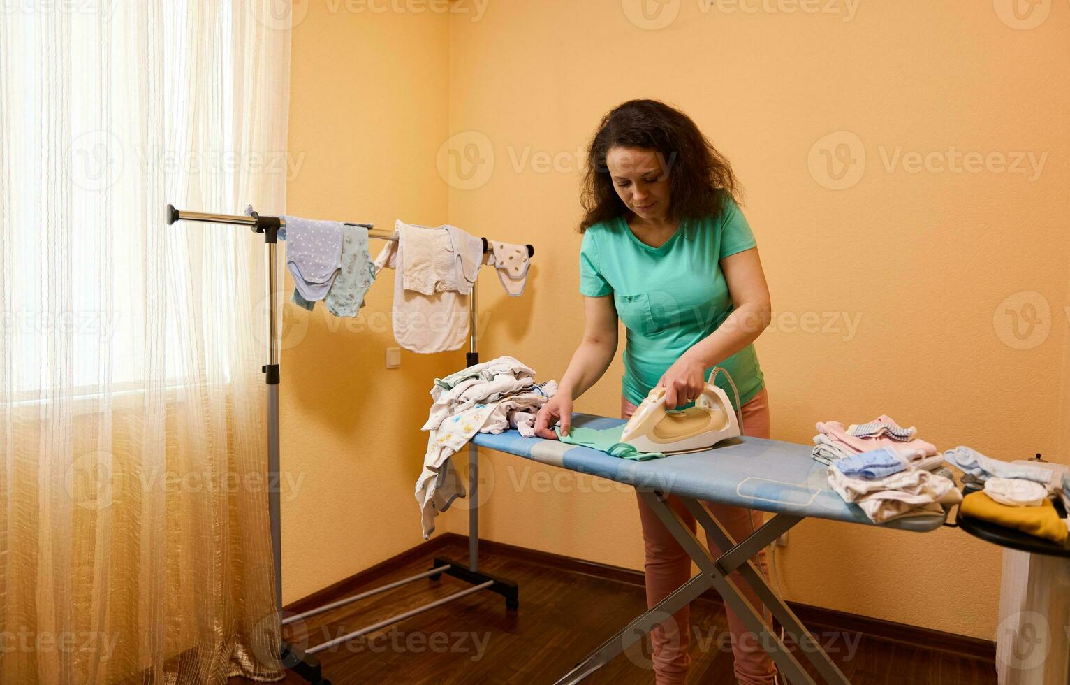 contento encantador embarazada joven mujer coleccionar un bebé bolso para un viaje a maternidad hospital, hierros bebé ropa a hogar foto