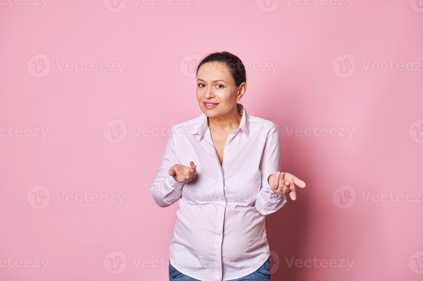 Pregnant confused woman, holding her hands palms up, asking question, expressing misunderstanding looking at camera photo