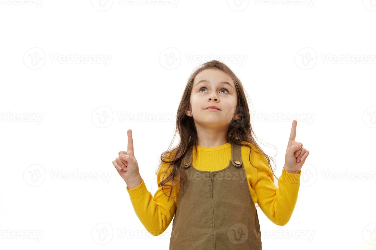 caucásico pequeño niño niña 5-6 años mirando aparte arriba, señalando su dedos arriba en aislado blanco antecedentes. Copiar espacio foto