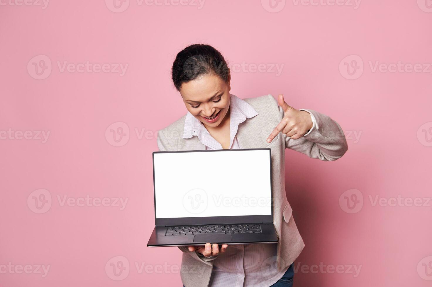 Smiling business woman office worker, manager showing on laptop a white digital screen with copy space for mobile apps photo