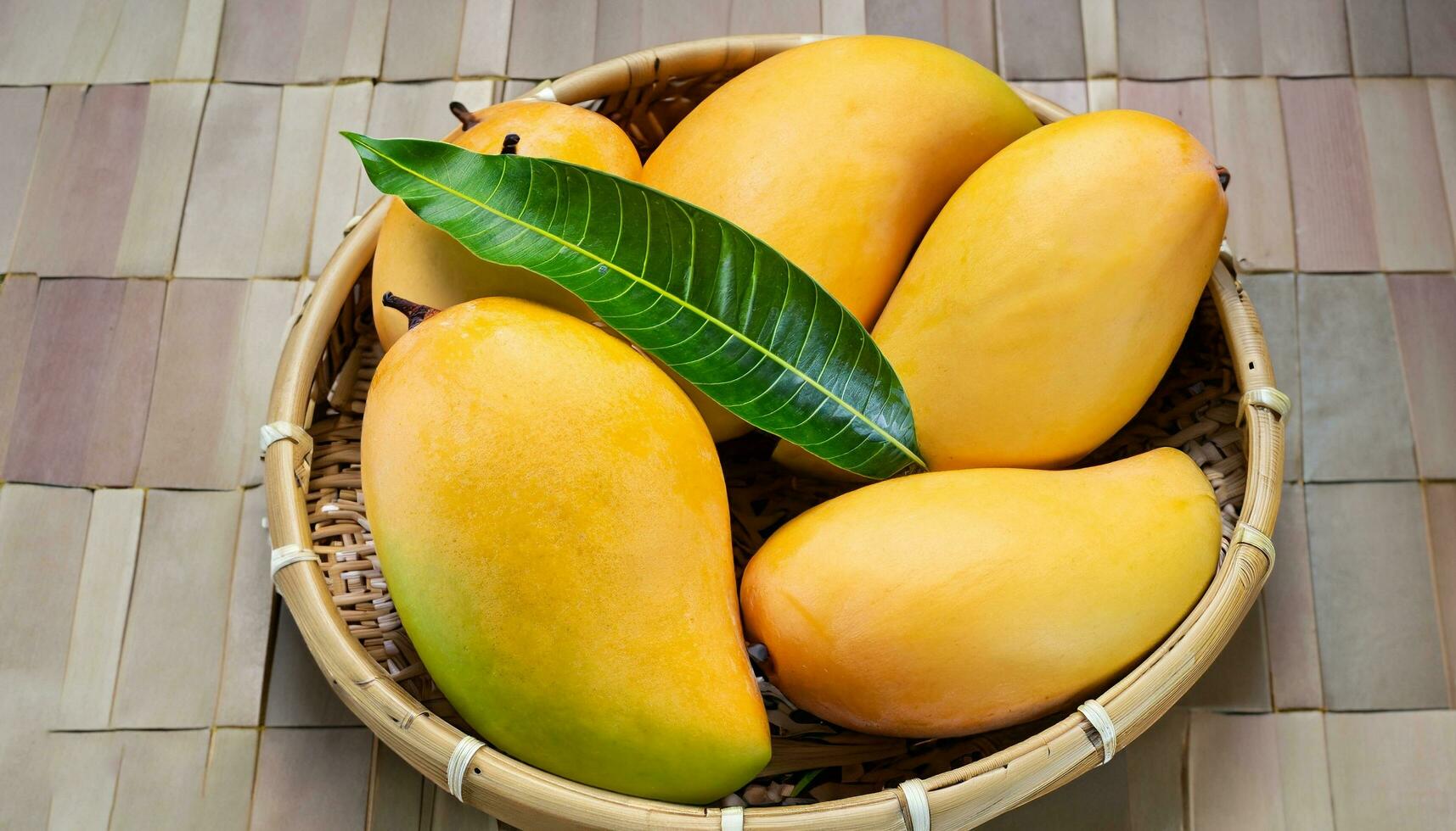 Mango fruit hanging on a tree with a rustic wooden table photo
