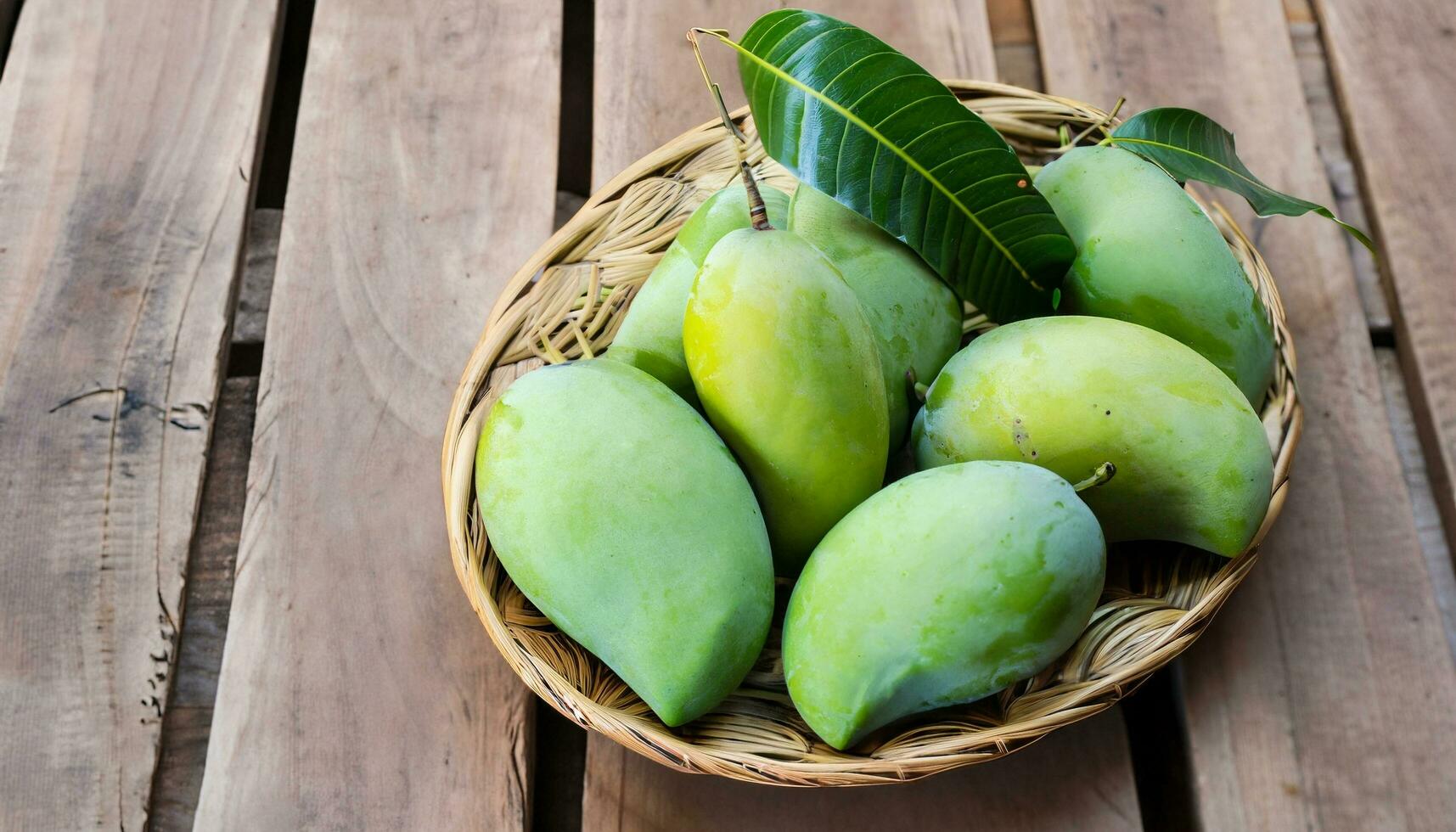 Mango fruit hanging on a tree with a rustic wooden table photo