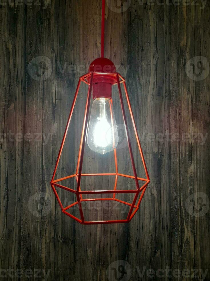 Decorative chandelier with light bulb. Decorative chandelier on wood background photo