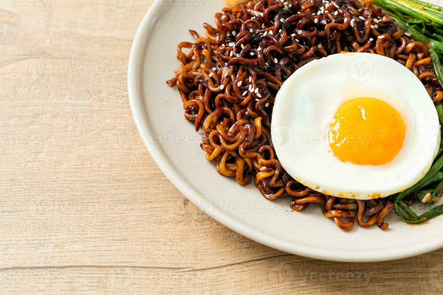 dried Korean spicy black sauce instant noodles with fried egg and kimchi photo