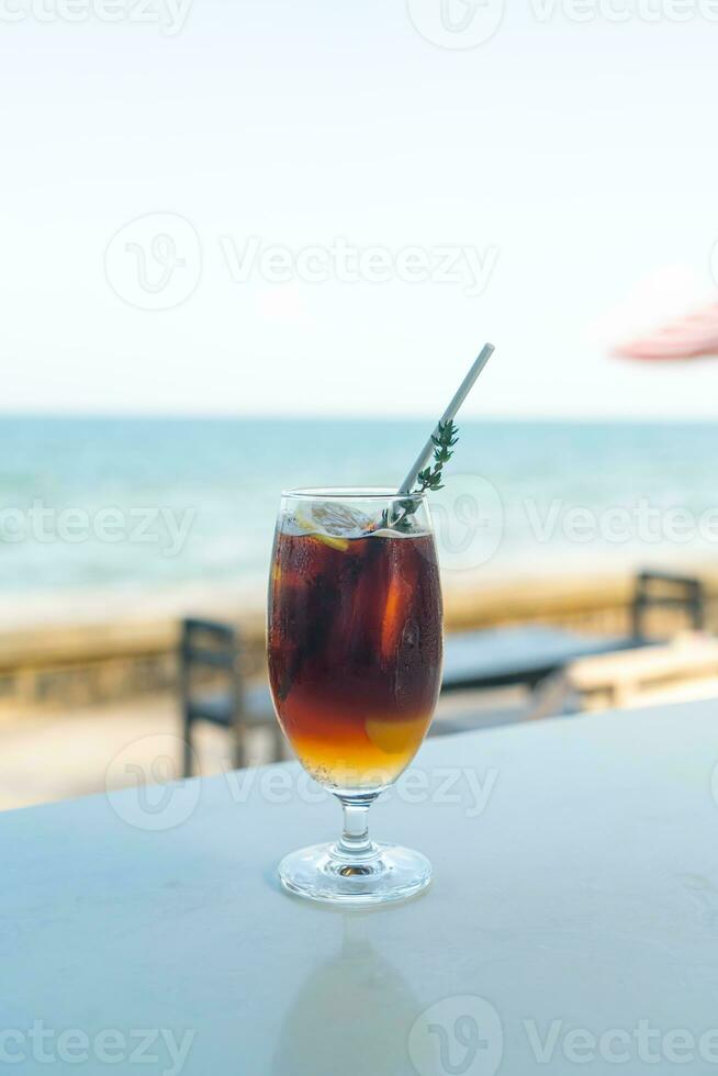 iced americano coffee peach with sea background photo