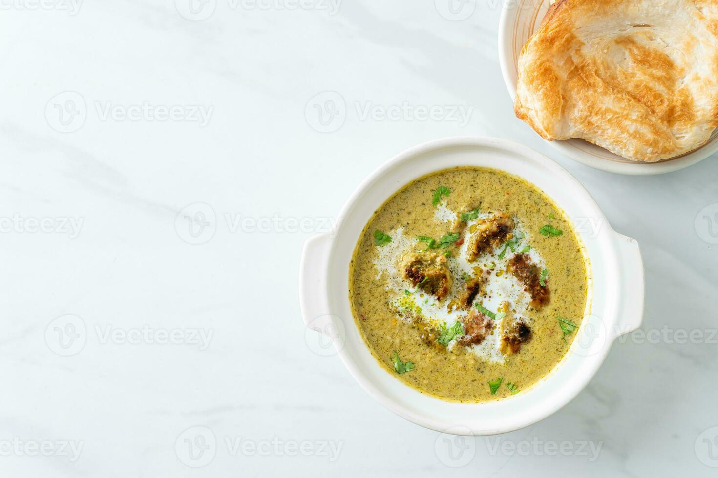 Afghani chicken in green masala curry or Hariyali tikka chicken hara masala with roti or naan bread photo