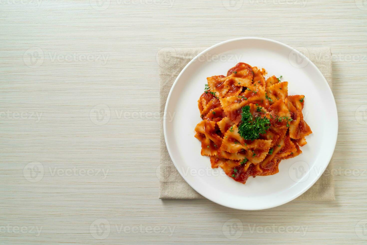 farfalle pasta in tomato sauce with parsley photo