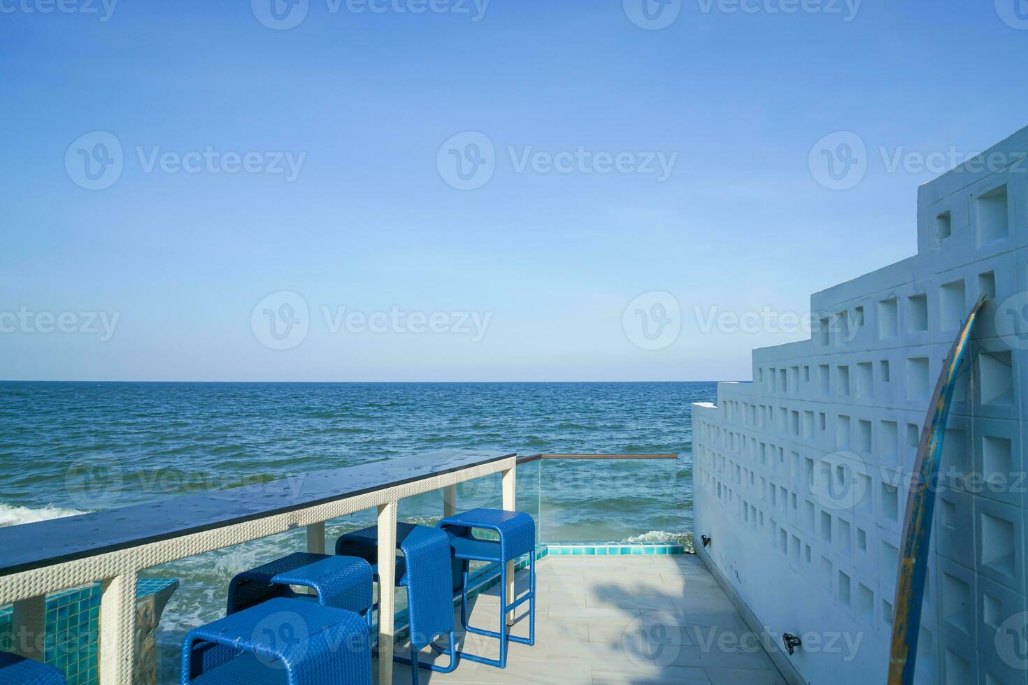 desk and bar stool near swimming pool with sea background 23738949