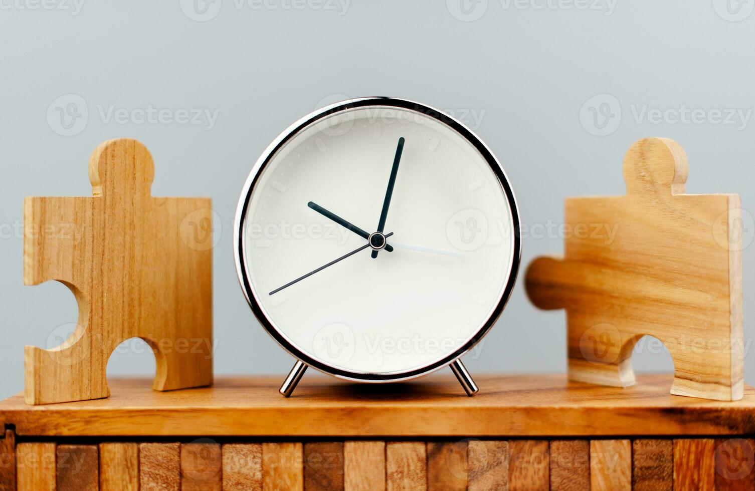 Clock next to the jigsaw puzzle piece working against time concept of time value of time photo