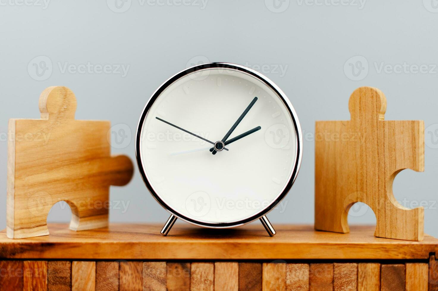 Clock next to the jigsaw puzzle piece working against time concept of time value of time photo