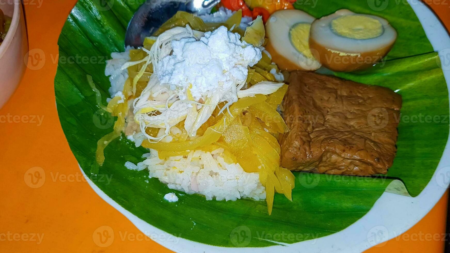 Indonesian food Liwet Rice. A Traditional javanese Rice Served with Chicken, Tofu, Tempeh, vegetable, Chili and Broad Beans photo