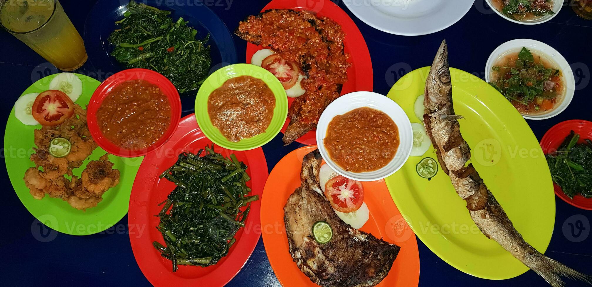 Seafood dish served on the table and plate from above with different kind of dish from fried fish barracuda, snapper, tuna jaws, and also mix of tropical vegetables photo