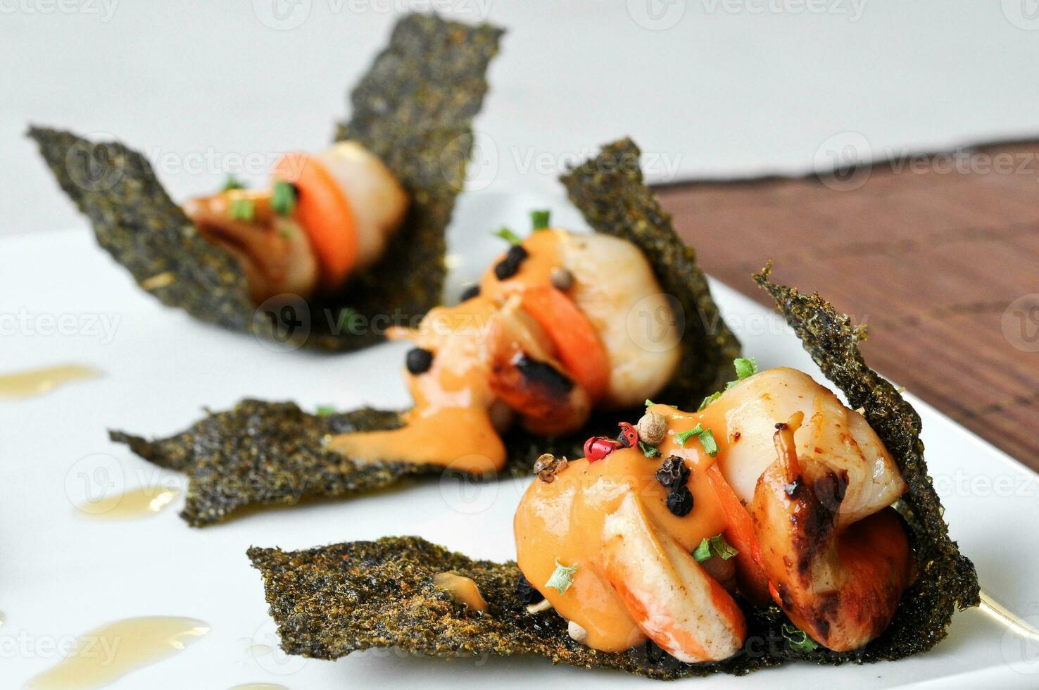 grilled scallops with sour sauce on crispy seaweed photo