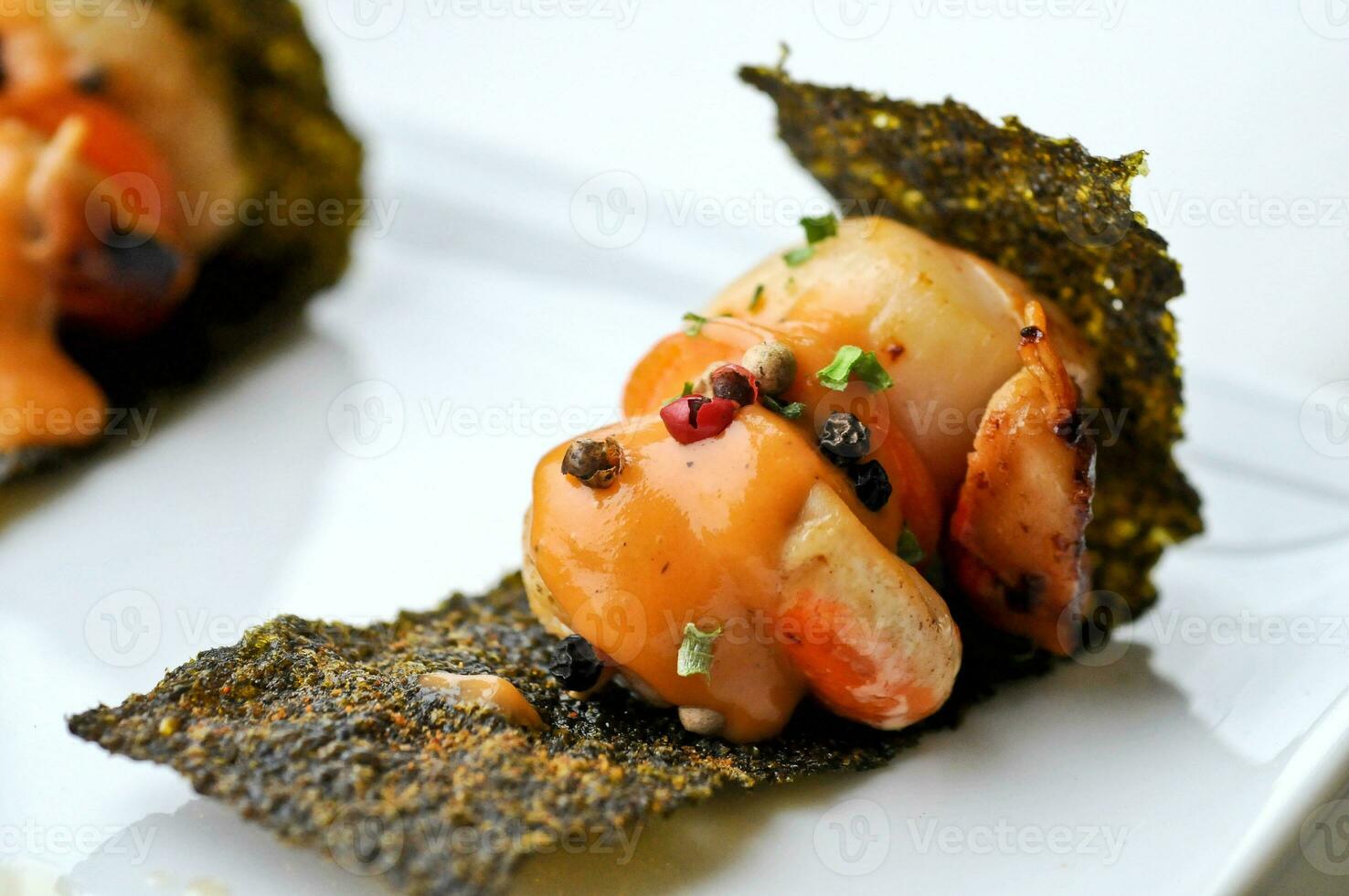 Delicacy grilled scallops with sour sauce on crispy seaweed photo