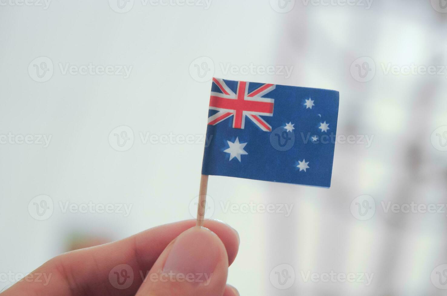 Mini Australian national flag holding by fingers photo