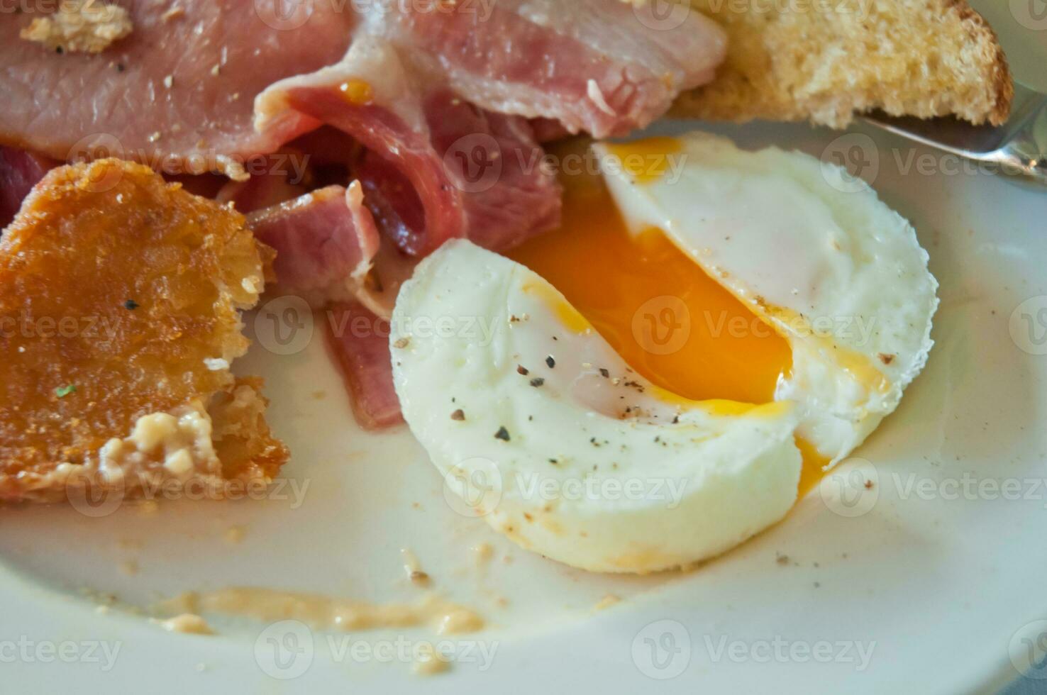 English breakfast - poached yummy half-cooked eggs and bacon photo