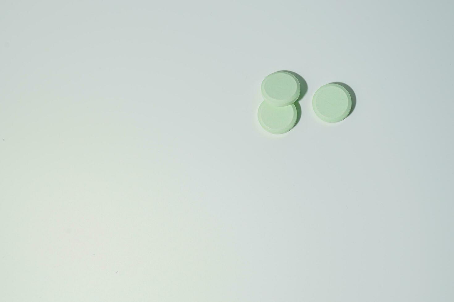 A bunch of medicinal pills and antibiotics, White medical tablets, light green, with copy space. photo