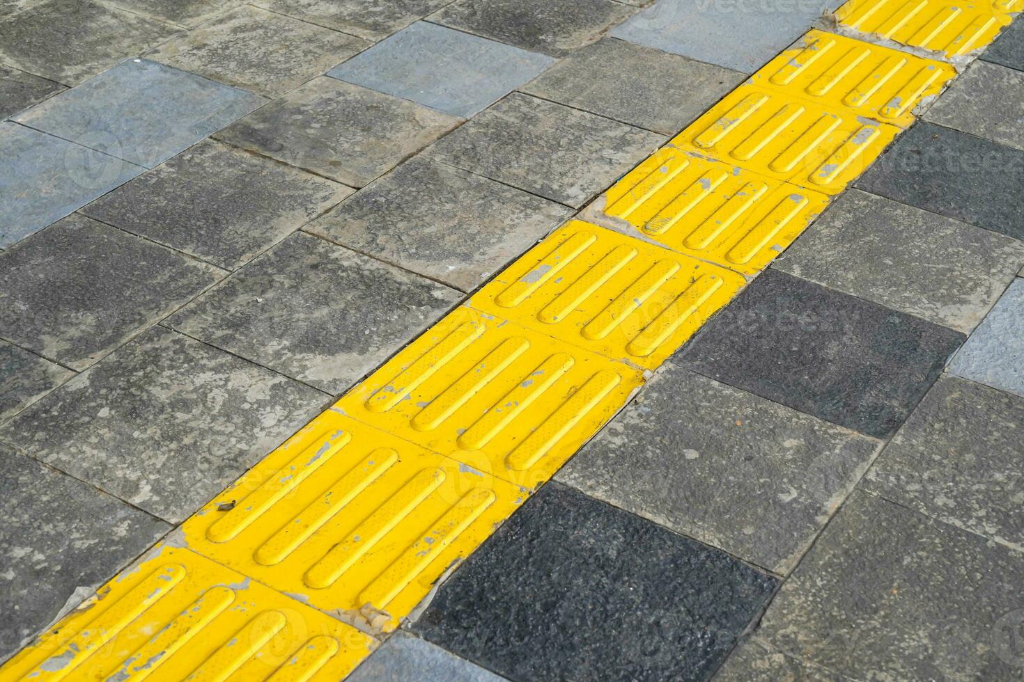 Pedestrian paths, Braille block in tactile paving for the blind handicapped in tiled pathways, paths for the blind. photo