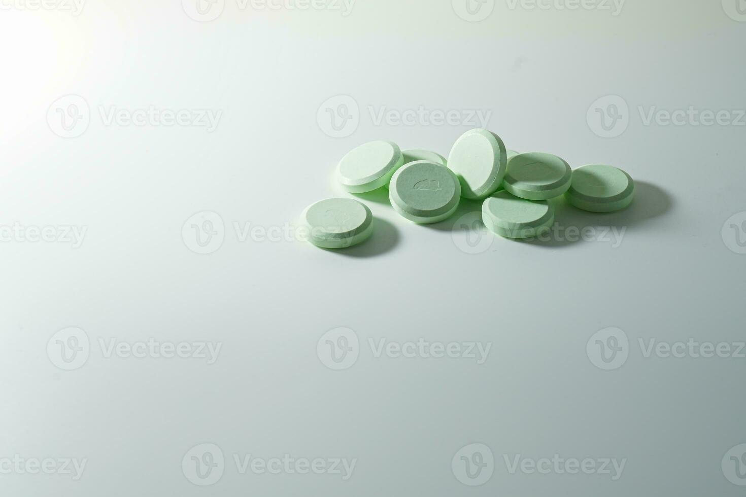 A bunch of medicinal pills and antibiotics, White medical tablets, light green, with copy space. photo