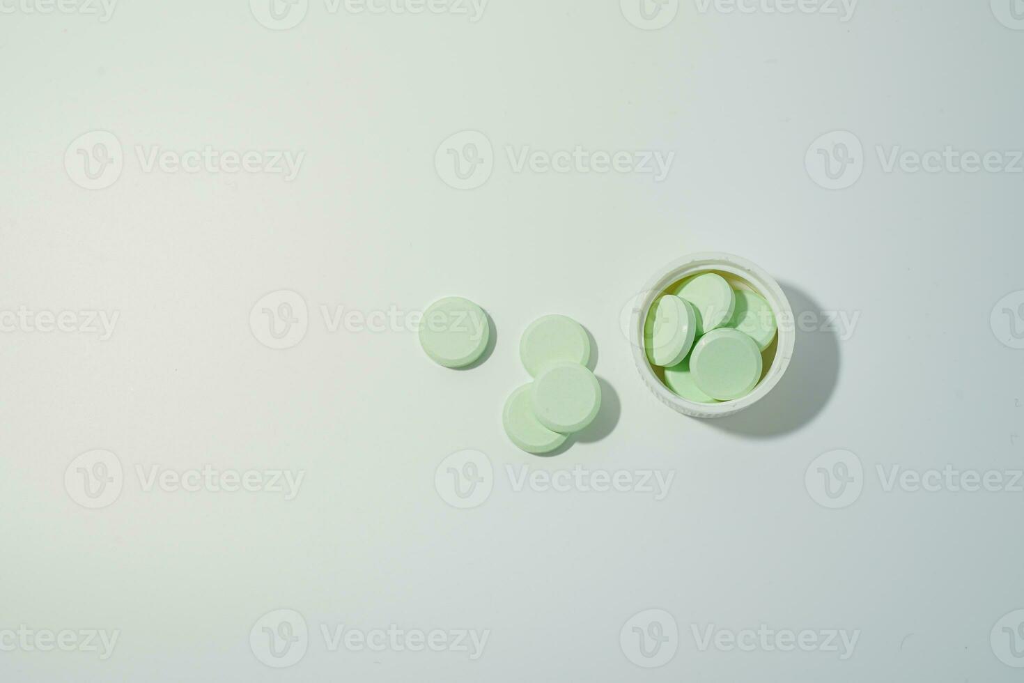 A bunch of medicinal pills and antibiotics, White medical tablets, light green, with copy space. photo