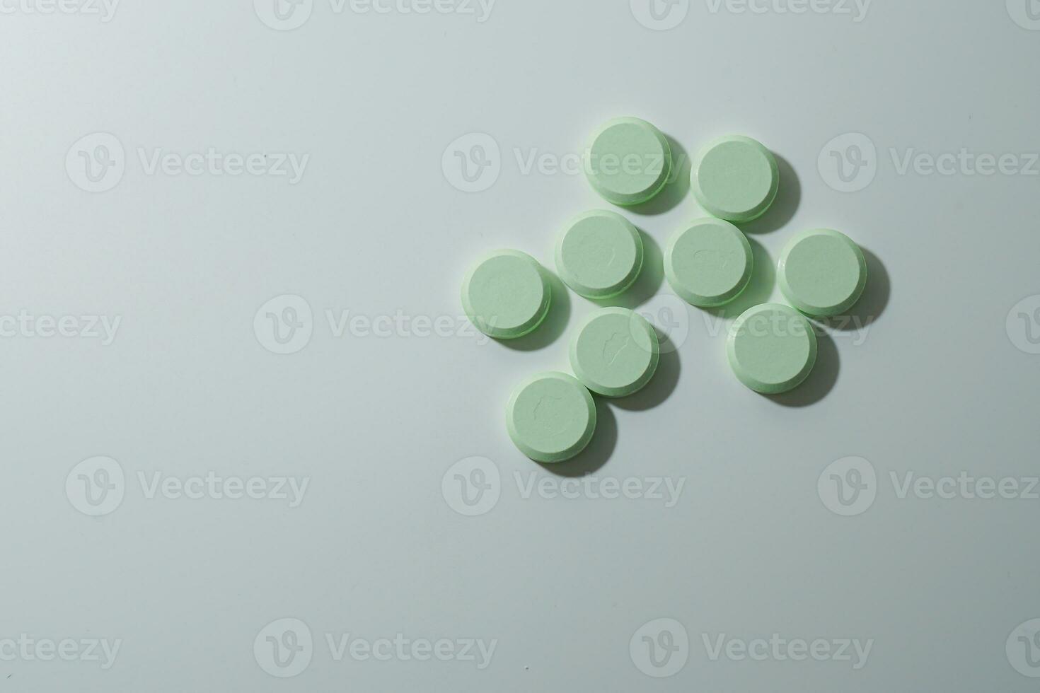 A bunch of medicinal pills and antibiotics, White medical tablets, light green, with copy space. photo