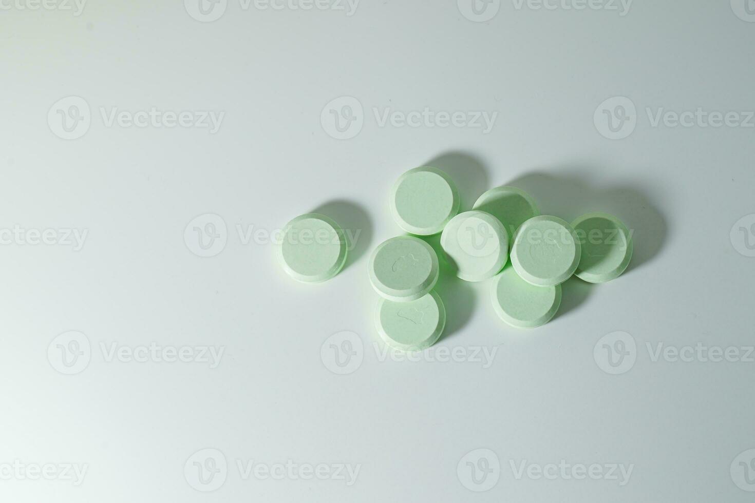 A bunch of medicinal pills and antibiotics, White medical tablets, light green, with copy space. photo