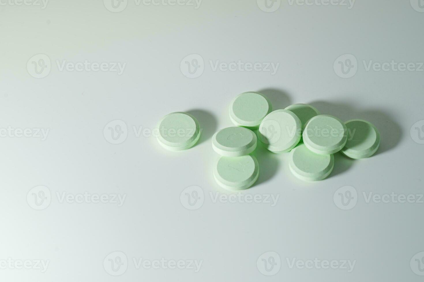 A bunch of medicinal pills and antibiotics, White medical tablets, light green, with copy space. photo