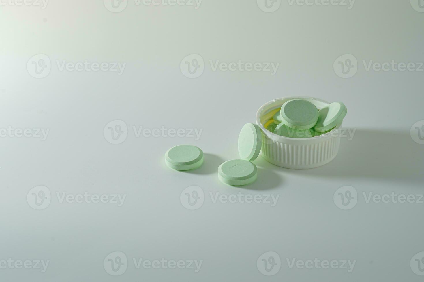 A bunch of medicinal pills and antibiotics, White medical tablets, light green, with copy space. photo