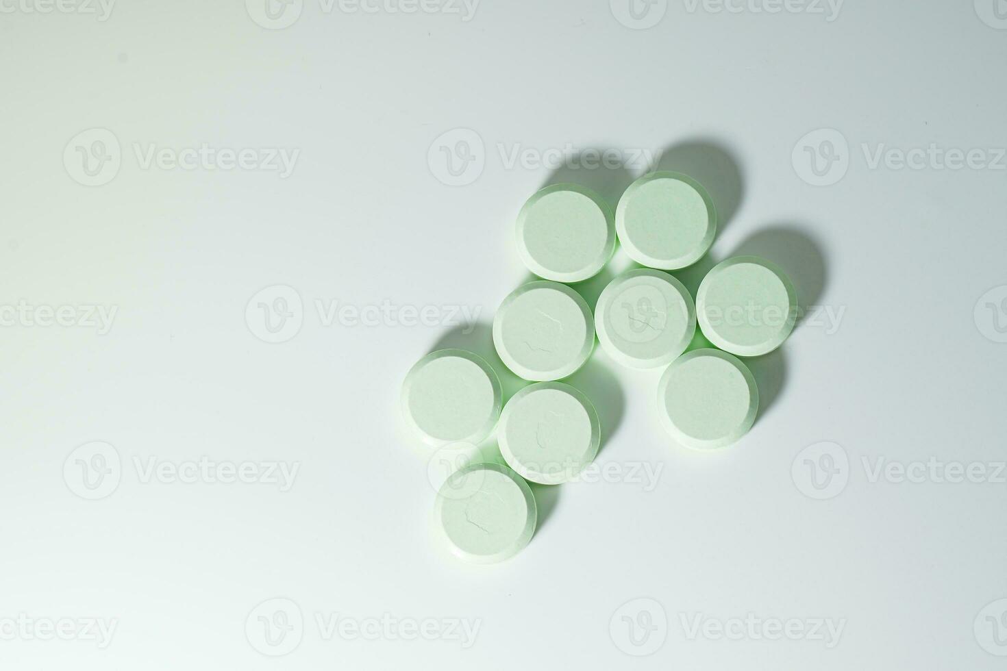 A bunch of medicinal pills and antibiotics, White medical tablets, light green, with copy space. photo