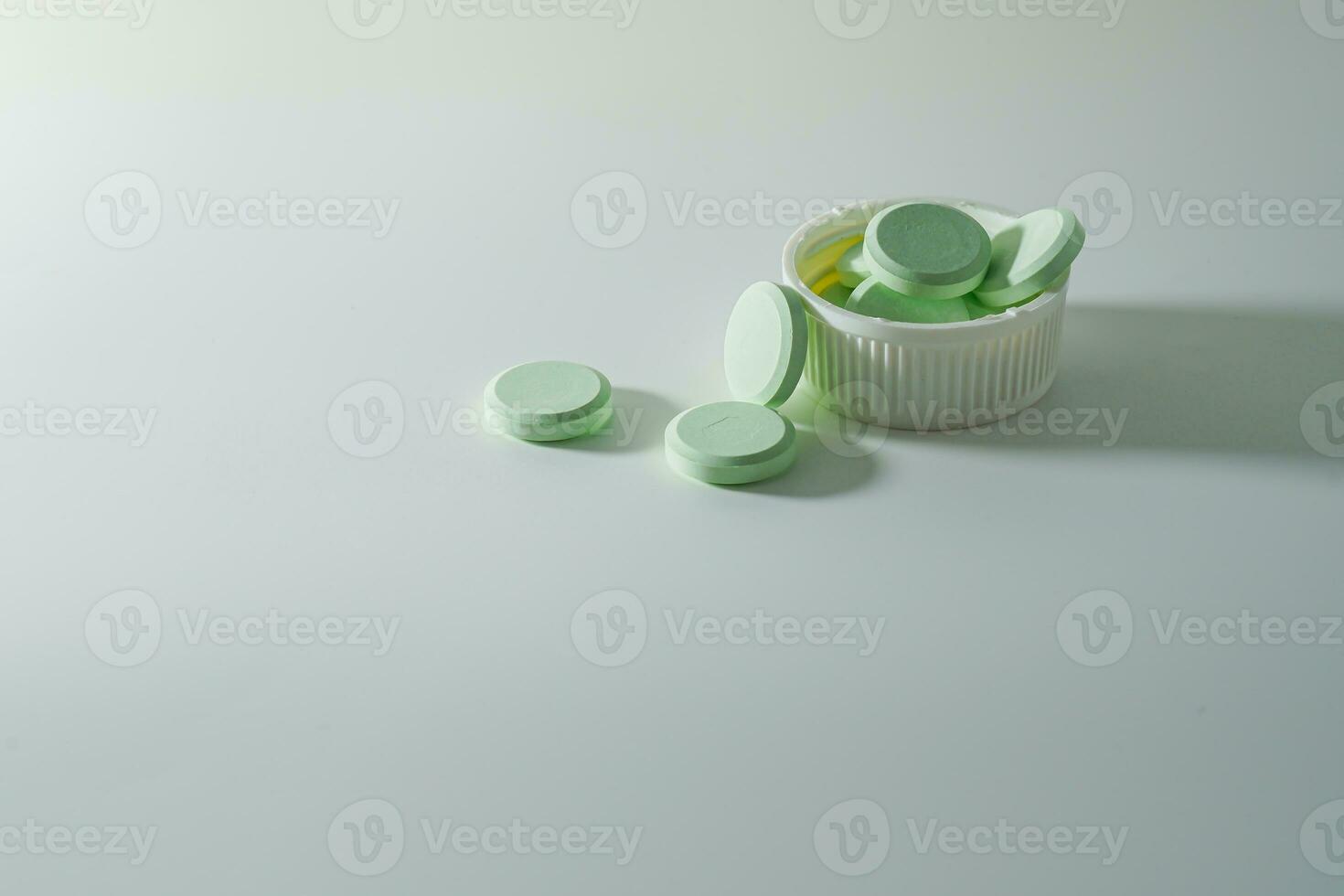 A bunch of medicinal pills and antibiotics, White medical tablets, light green, with copy space. photo