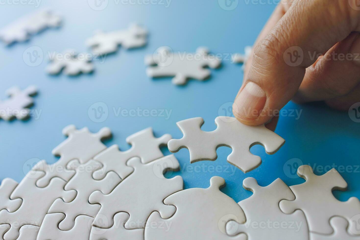 Hand put the last piece of jigsaw puzzle to complete the mission. Completing final task, missing jigsaw puzzle pieces and business concept with a puzzle piece missing. photo